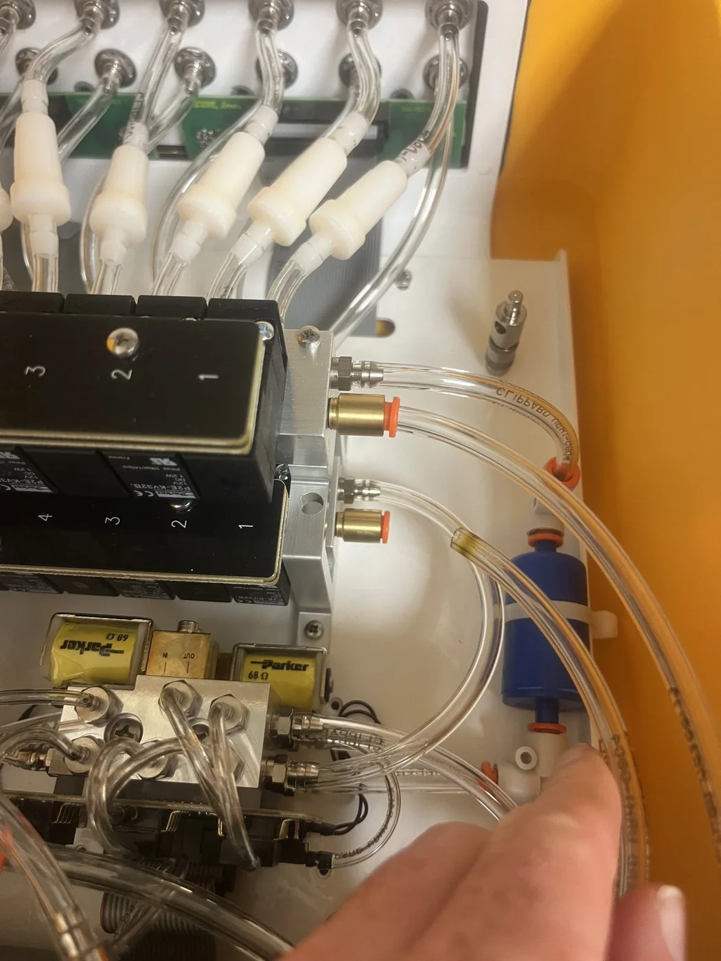Close-up of the LI-8250 multiplexer interior showing the sample manifold, Parker solenoid valves, and the tubing that routes one analyzer across eight flask ports.